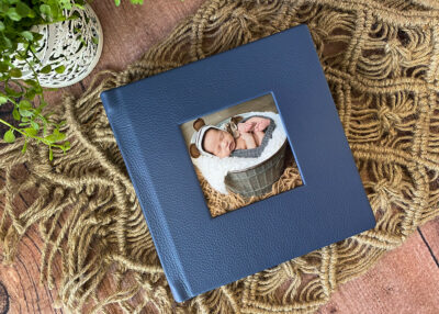 A blue photo album with a baby in it.