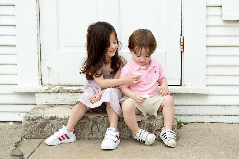 Two children sitting on the steps of a house in Gruene, Texas