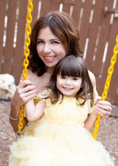 A woman and a child on a swing.