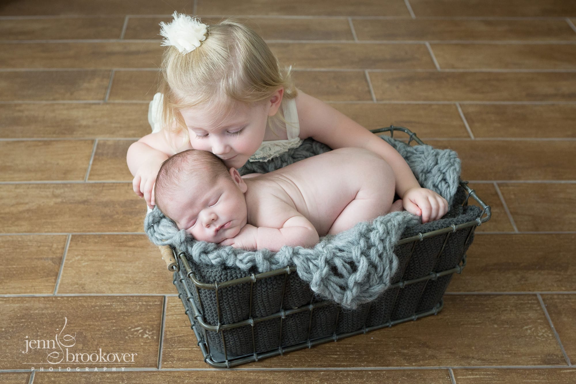 big sister kissing newborn baby brother during photo session