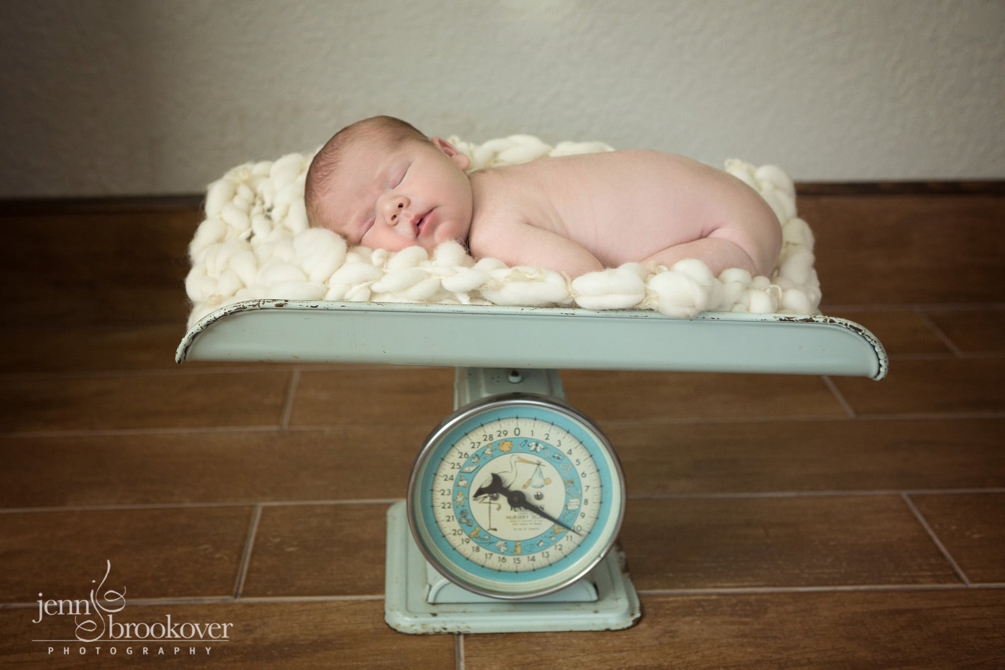 newborn asleep on vintage scale during newborn photo session