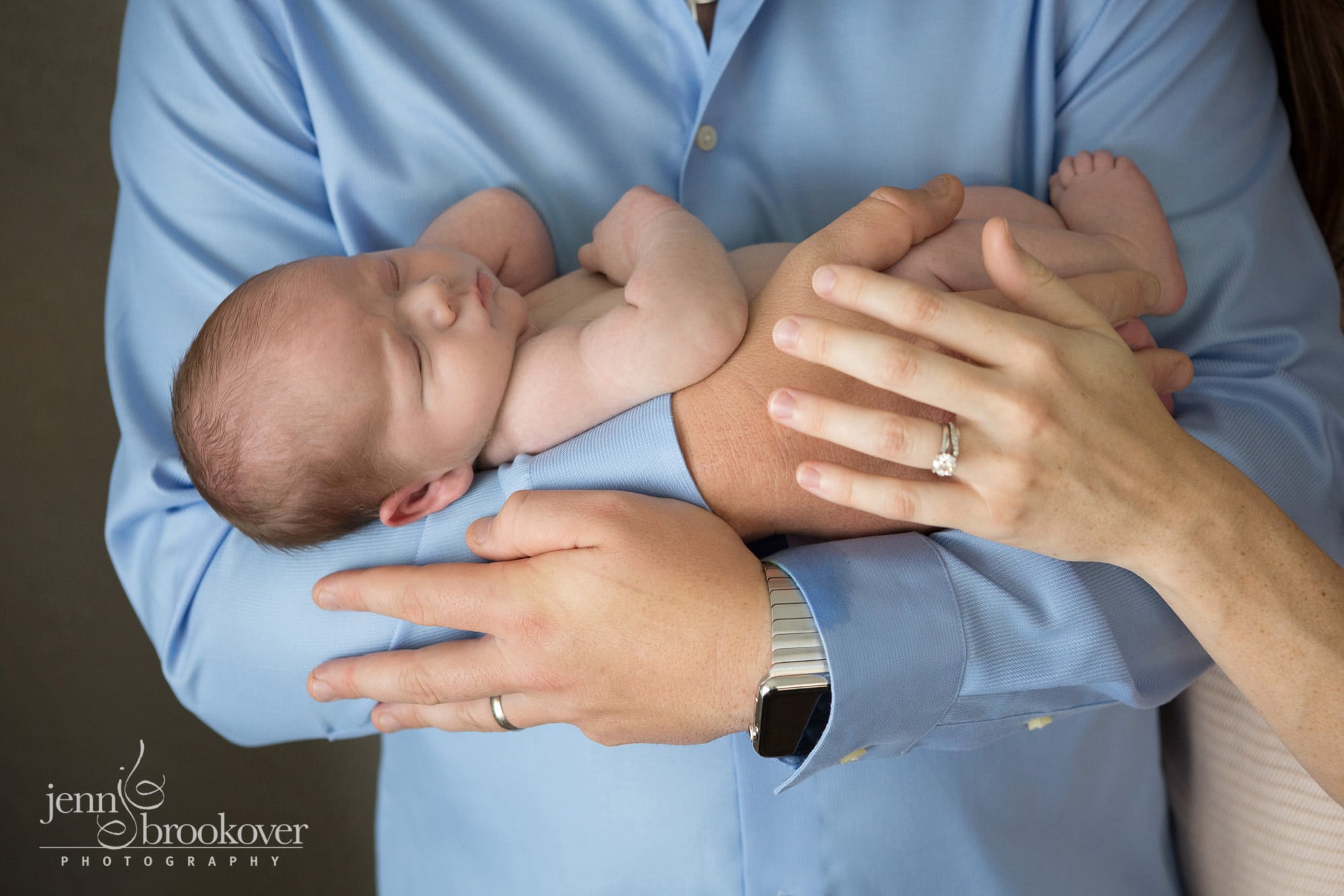 mom and dad holding newborn boy during photo session
