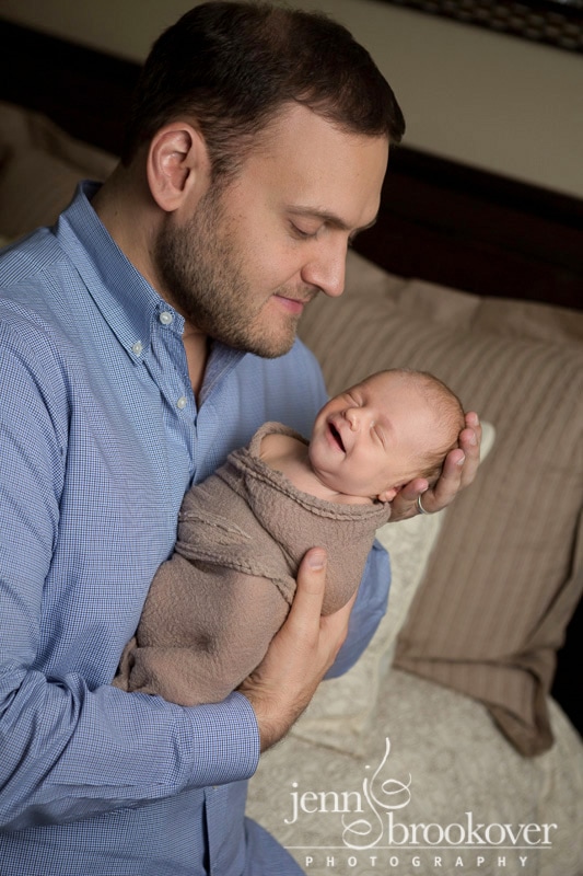 smiley baby boy newborn being held by dad during his newborn session in San Antonio by Jenn Brookover Photography