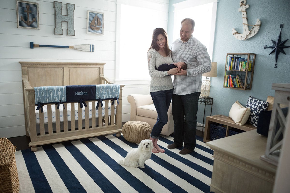 newborn parents and puppy in nautical nursery posted as part of Motherhood Musings feature