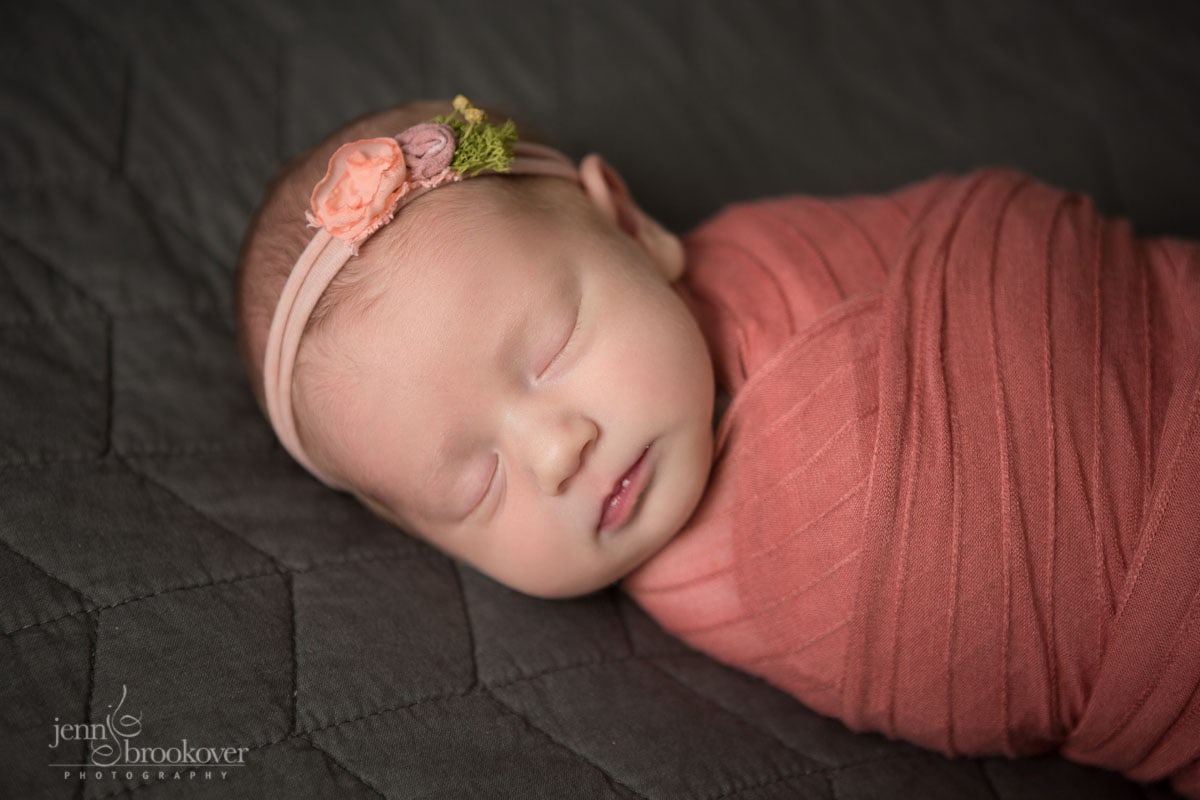 sleeping newborn portrait of baby wrapped in coral with flowered headband taken in San Antonio by Jenn Brookover