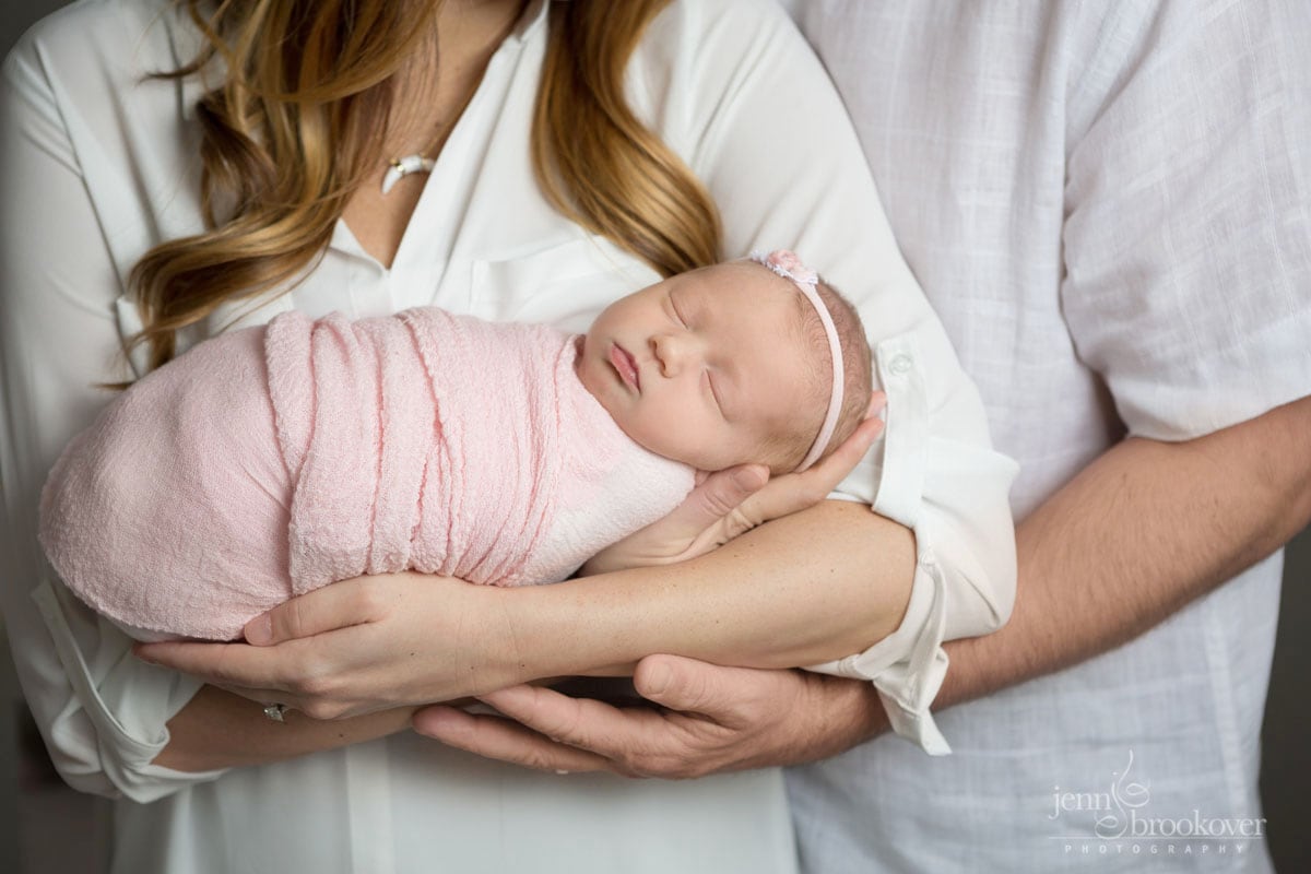 close up of baby girl in pink swaddle and custom headband taken by Jenn Brookover Photography in San Antonio
