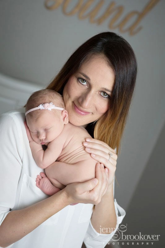 proud mama cuddling her new baby girl during her portrait session taken by Jenn Brookover