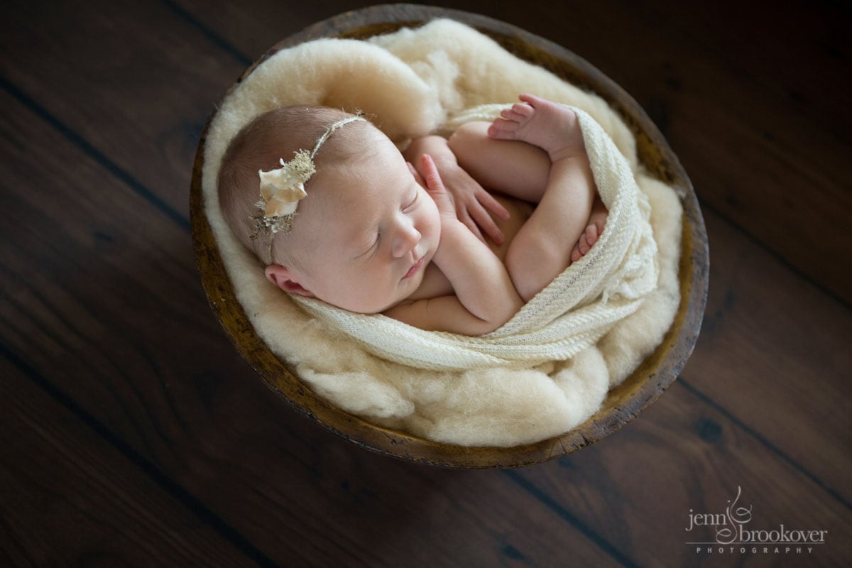 newborn cuddled up in cream wrap with headband by Myrtle and Moss by Jenn Brookover Photography