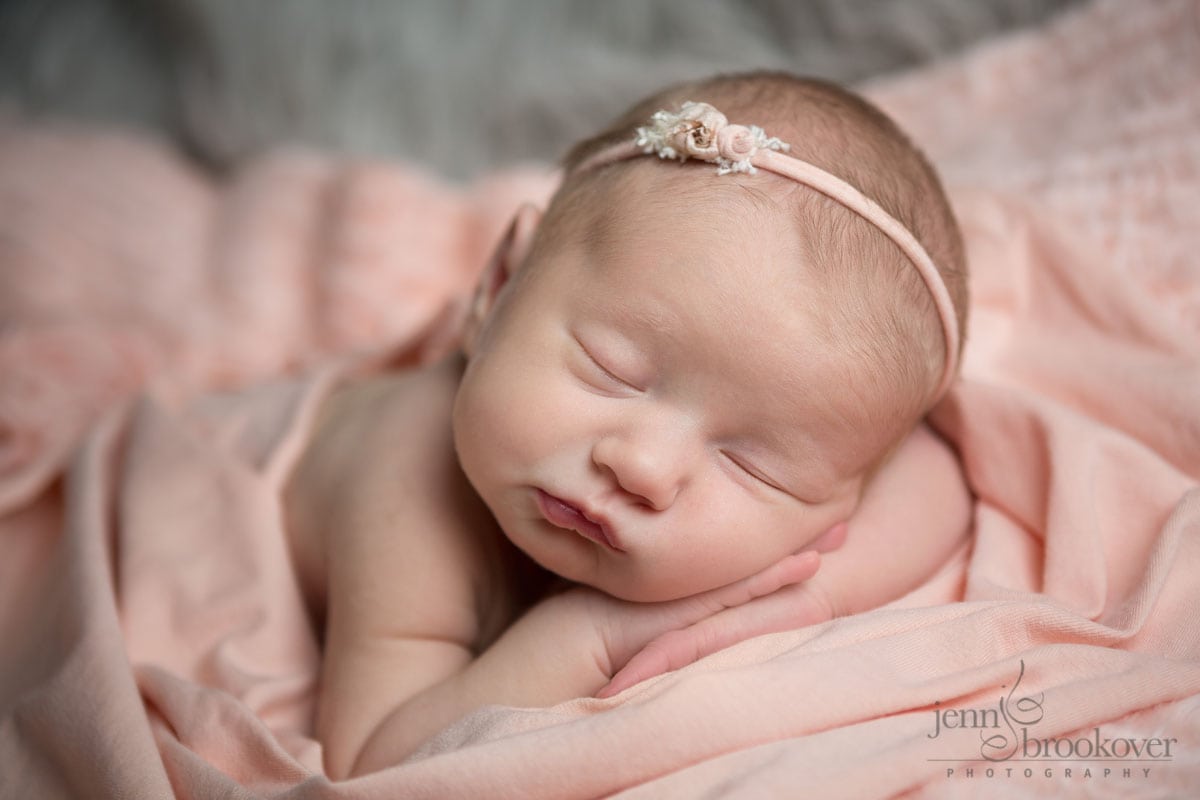 newborn girl wrapped in pink asleep for her newborn portraits in San Antonio