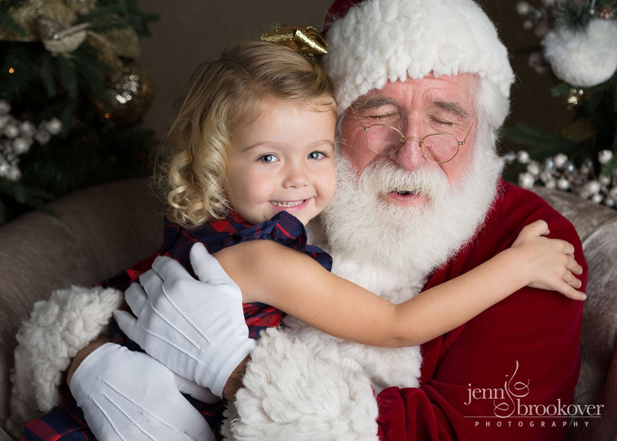 A little girl hugging santa claus.