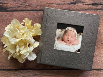 A photo of a newborn baby in a photo album.