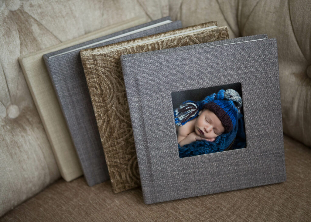 A photo of a baby sleeping in a book on a couch.