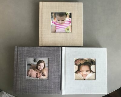 A set of three photo albums on a table.