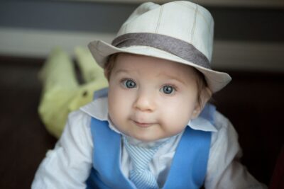 A baby wearing a hat and tie.