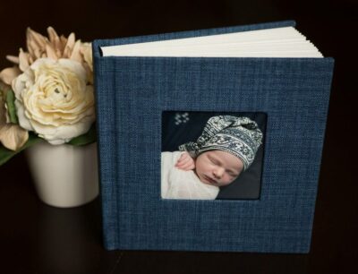 A photo of a newborn baby in a blue book.