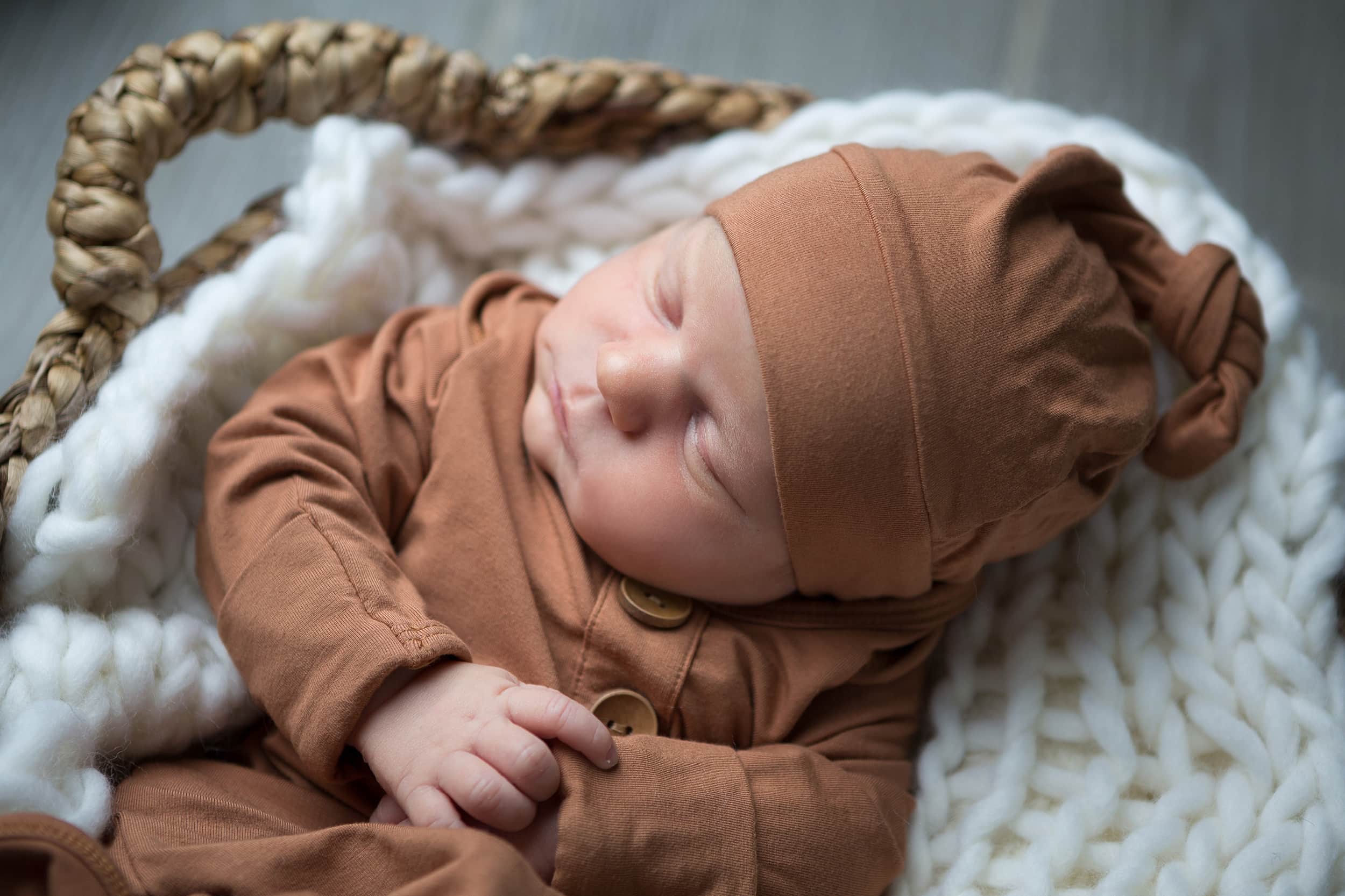 newborn boy in knotted Caden lane hat in home newborn session San Antonio