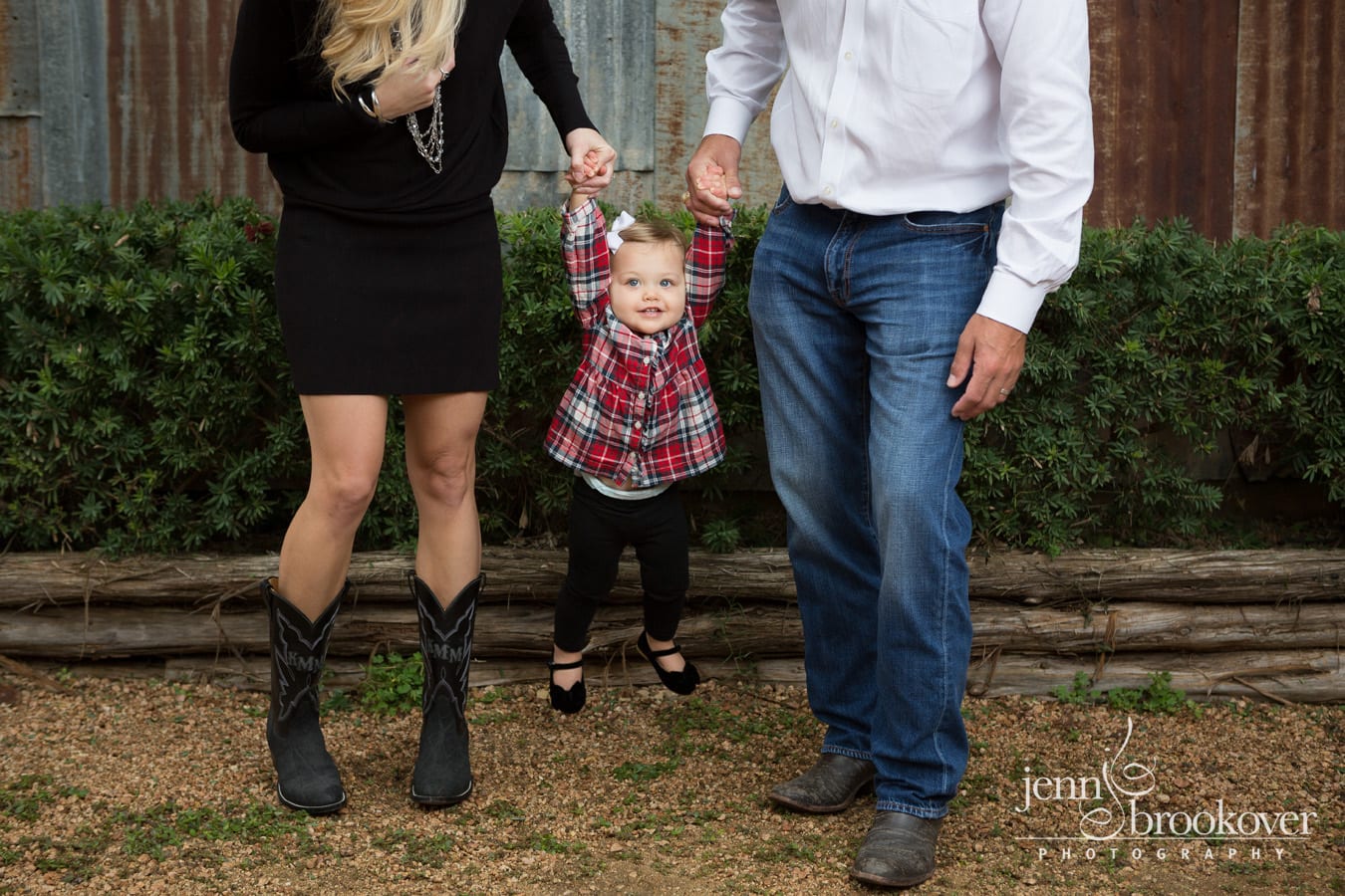 mom and dad swinging little girl during family photo session at Tejas Rodeo