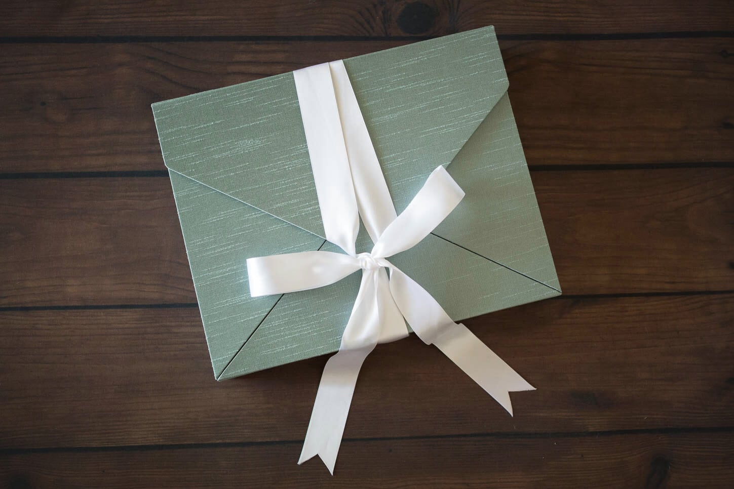 Silk memory portrait box in sage tied with a white silk ribbon