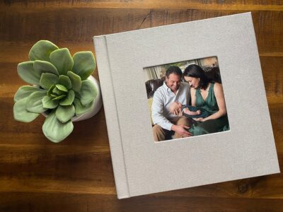 A photo album with a couple sitting on a table next to a plant.