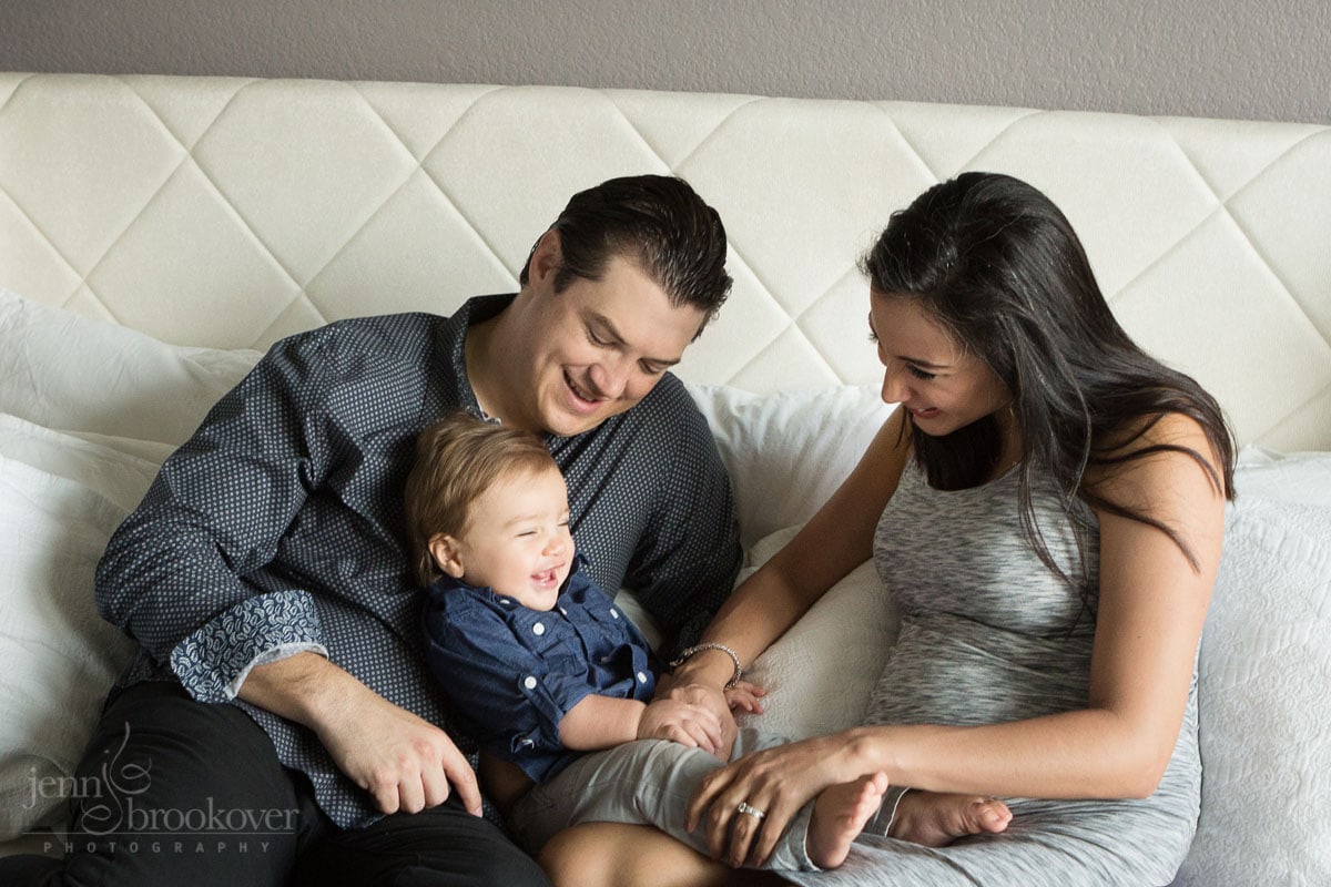 mom and dad tickling toddler during at home maternity session 
