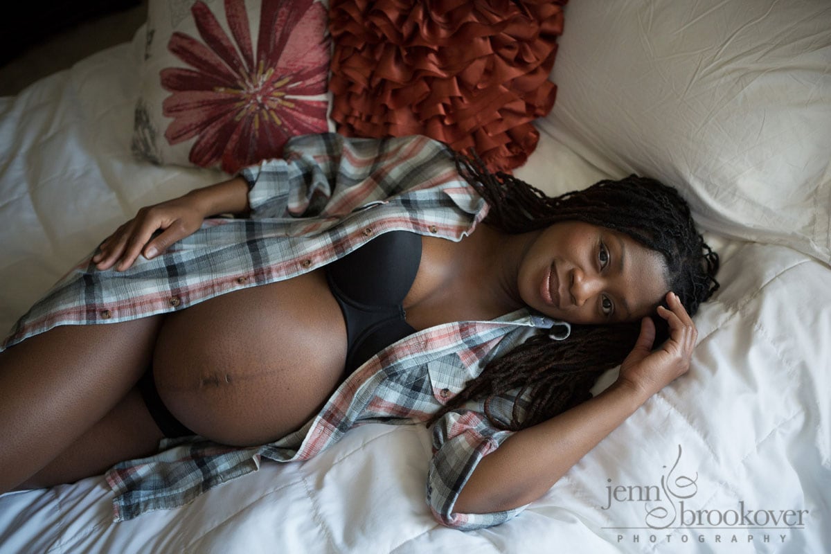 A pregnant woman laying on a bed.