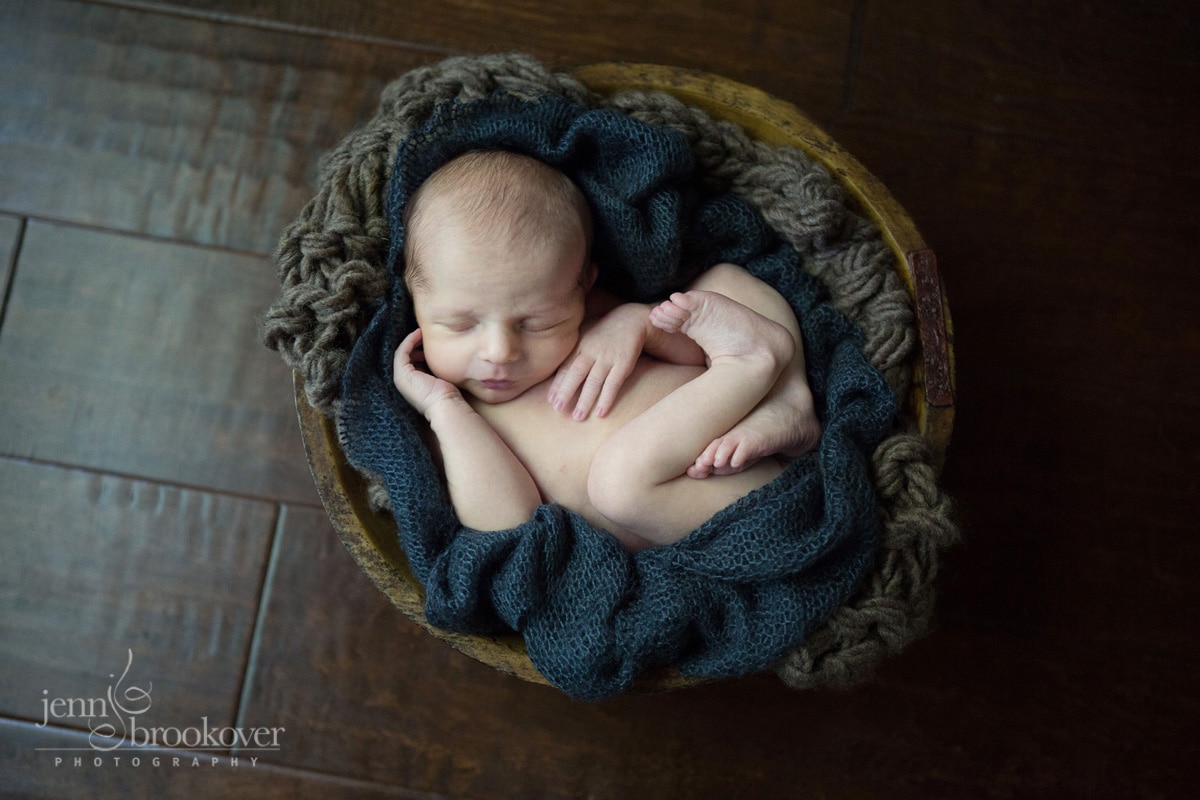 newborn in a bowl brown and blue during portrait session