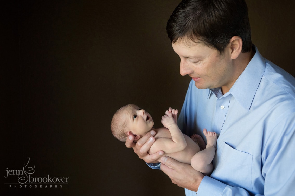 dad holding baby son during newborn session at home