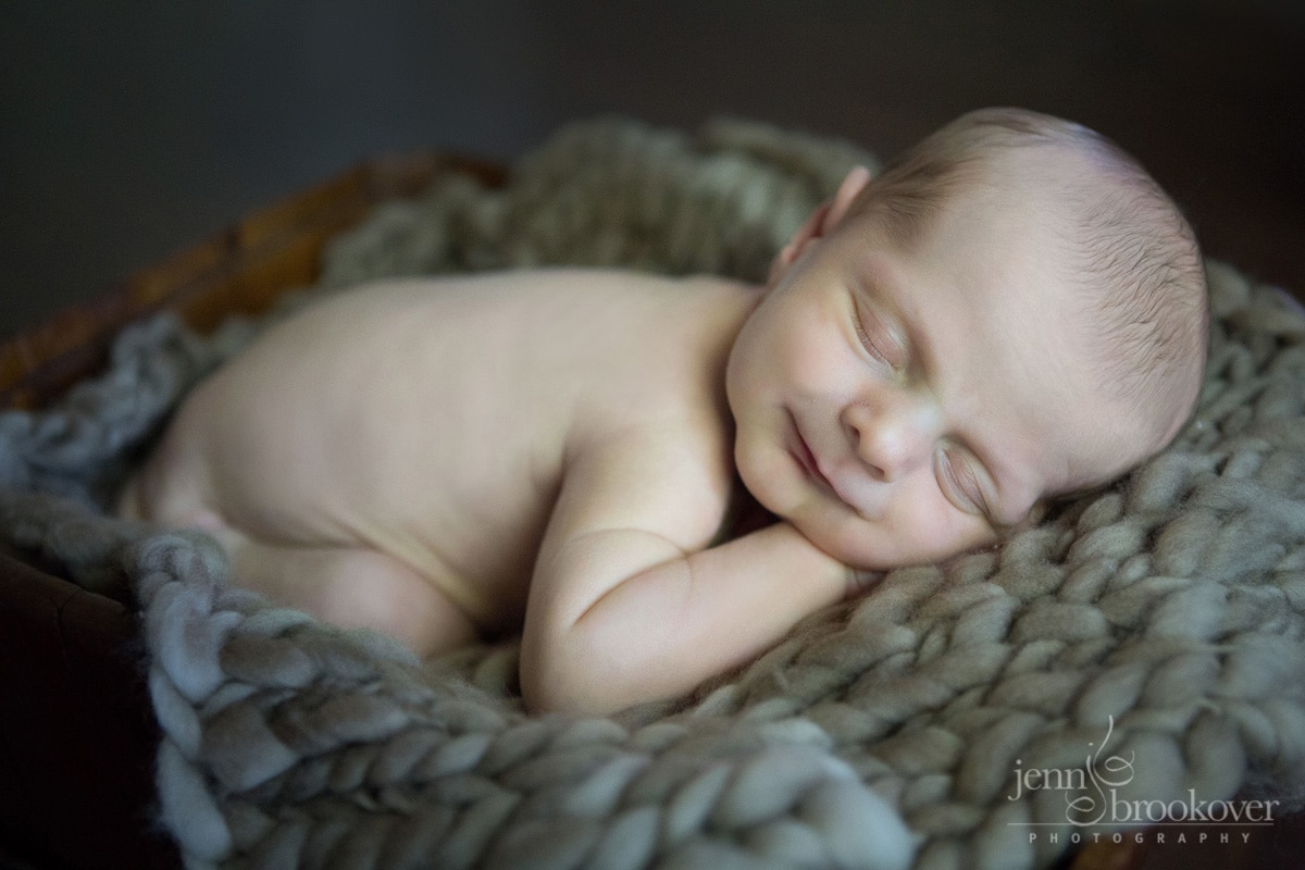 smiley newborn asleep during photo session at home