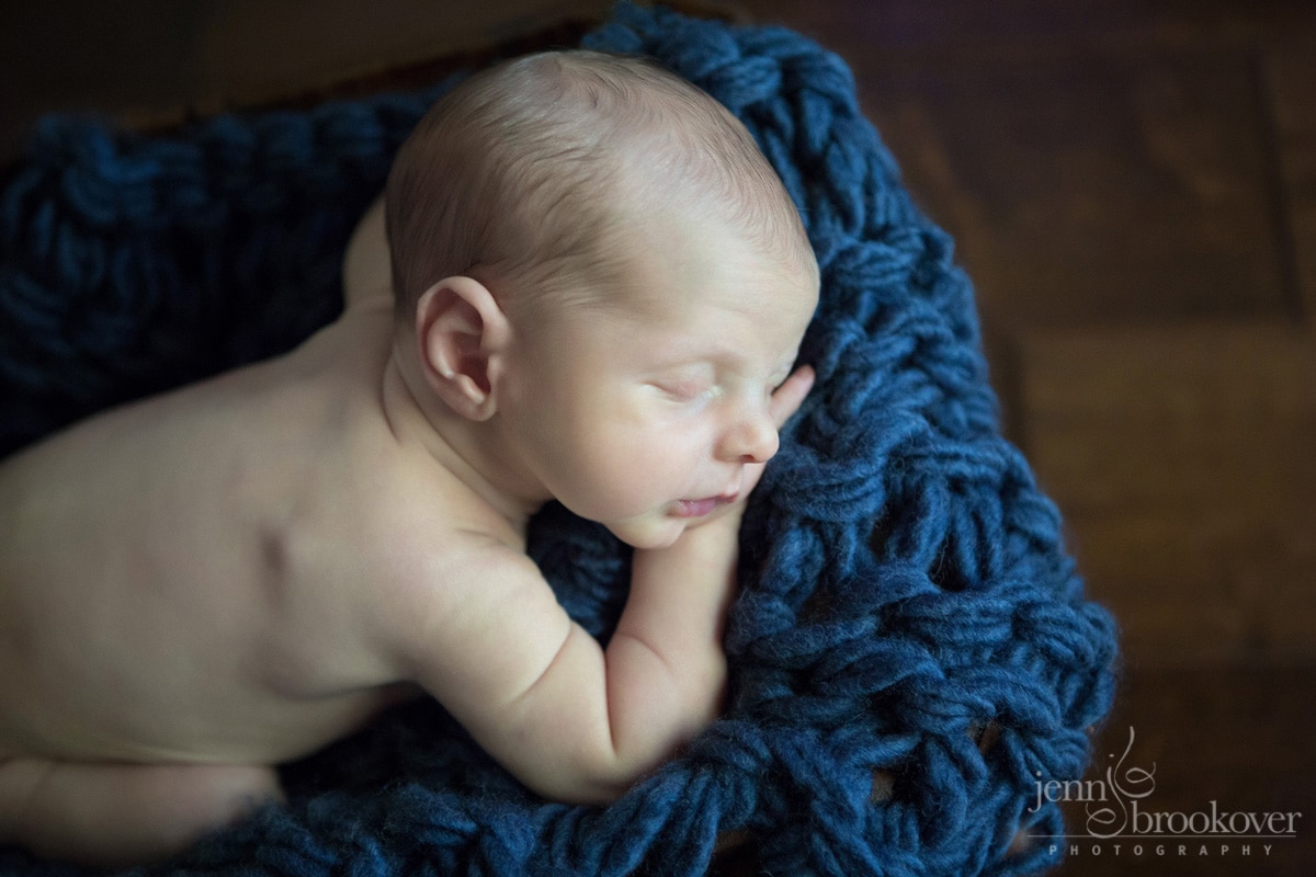 newborn sleeping on blue during portrait session