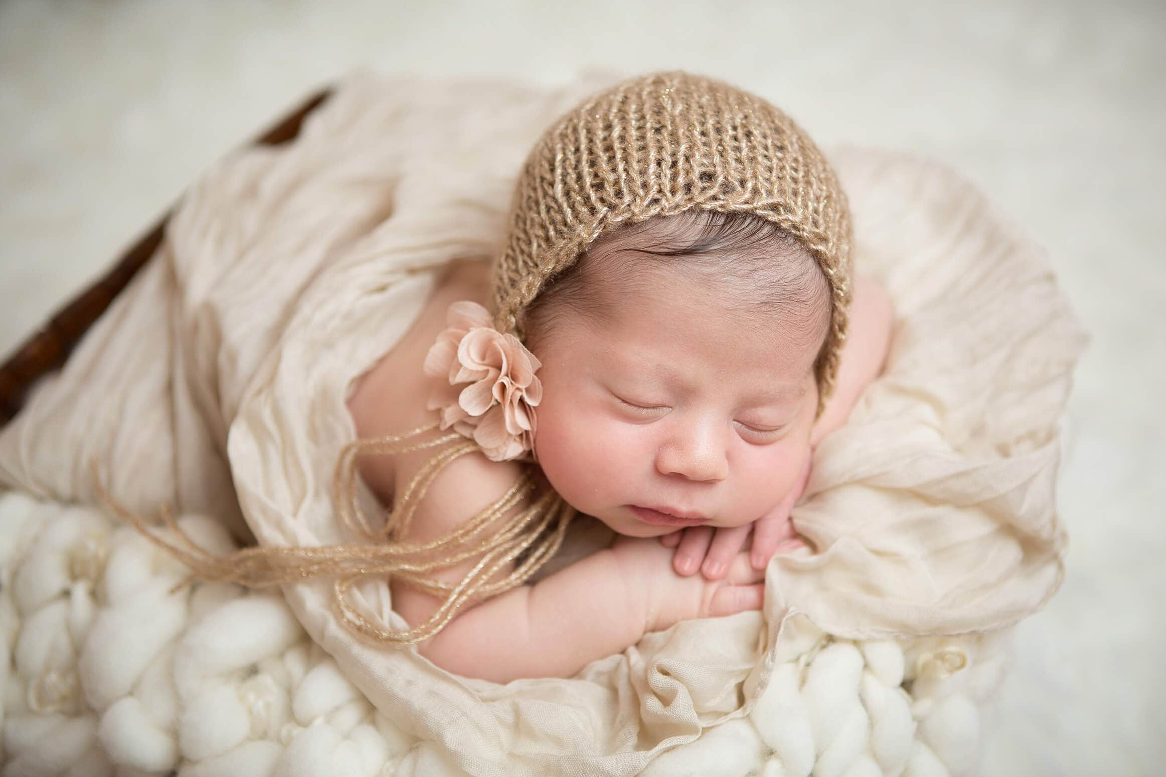 newborn girl in a gold knitted hat