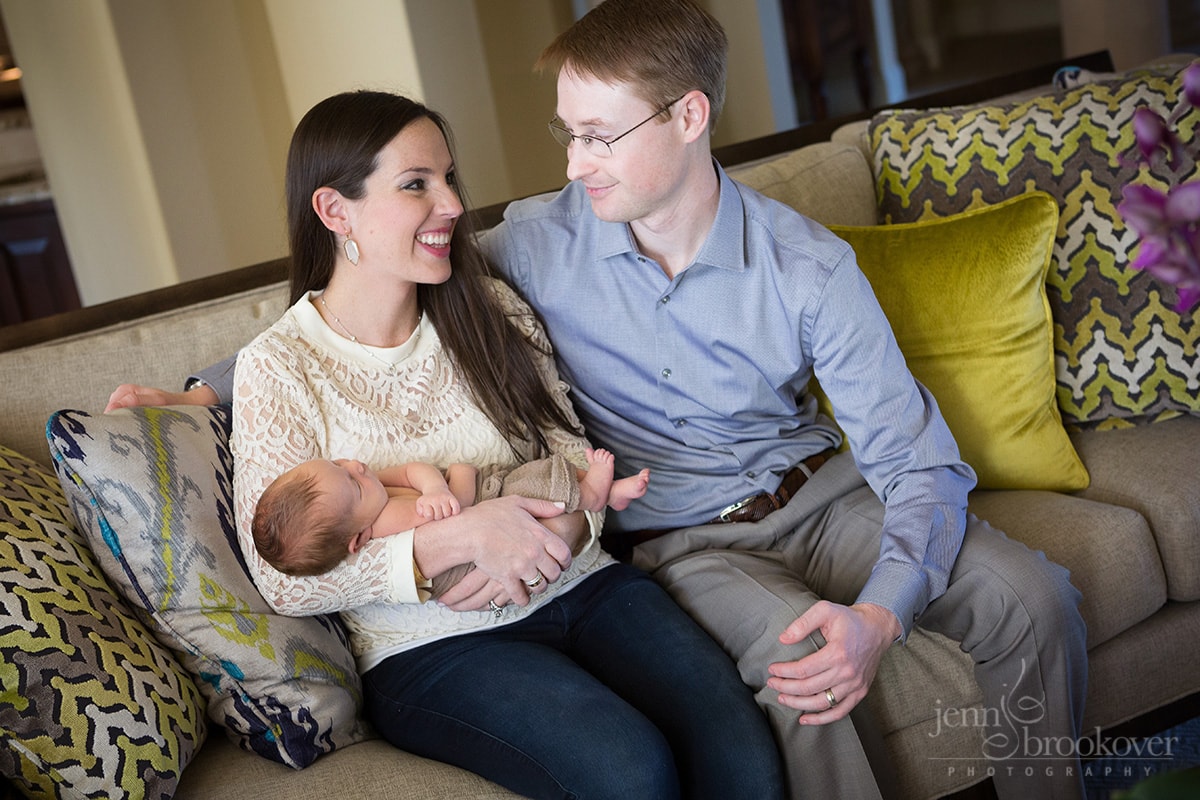 newborn at home with mom and dad on bright couch