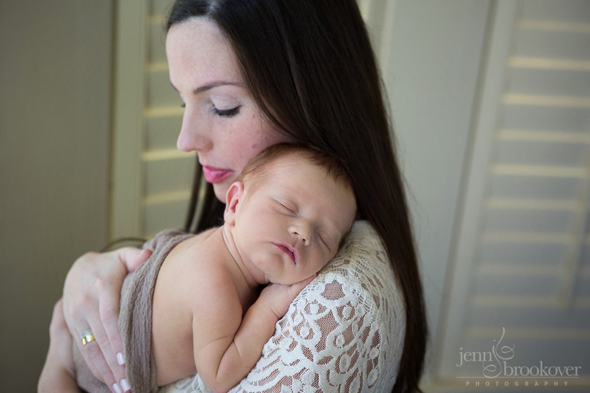 newborn over mom's shoulder in nursery at home in San Antonio