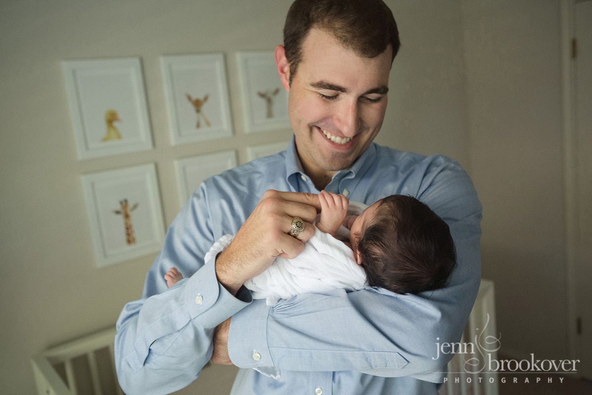 newborn with dad holding hands during lifestyle photo session