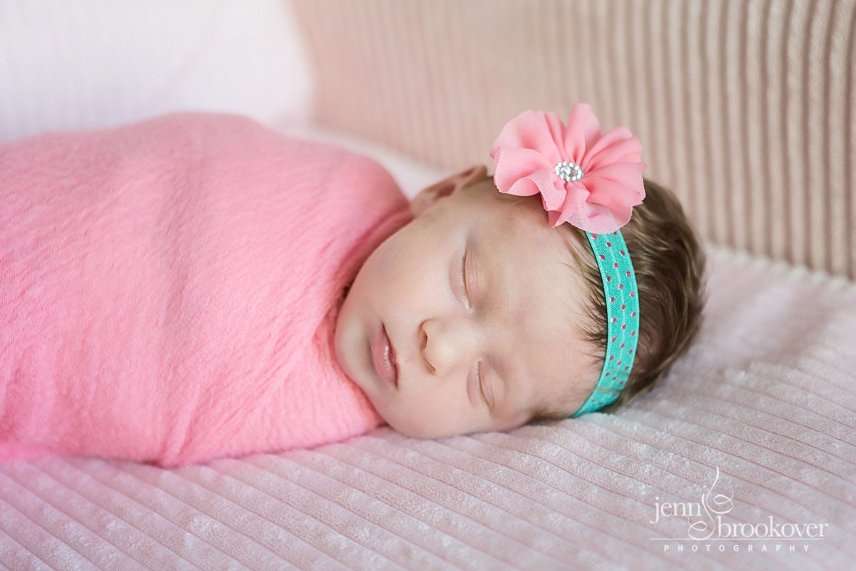 newborn photography at home in San Antonio, Texas, baby in pink with a headband