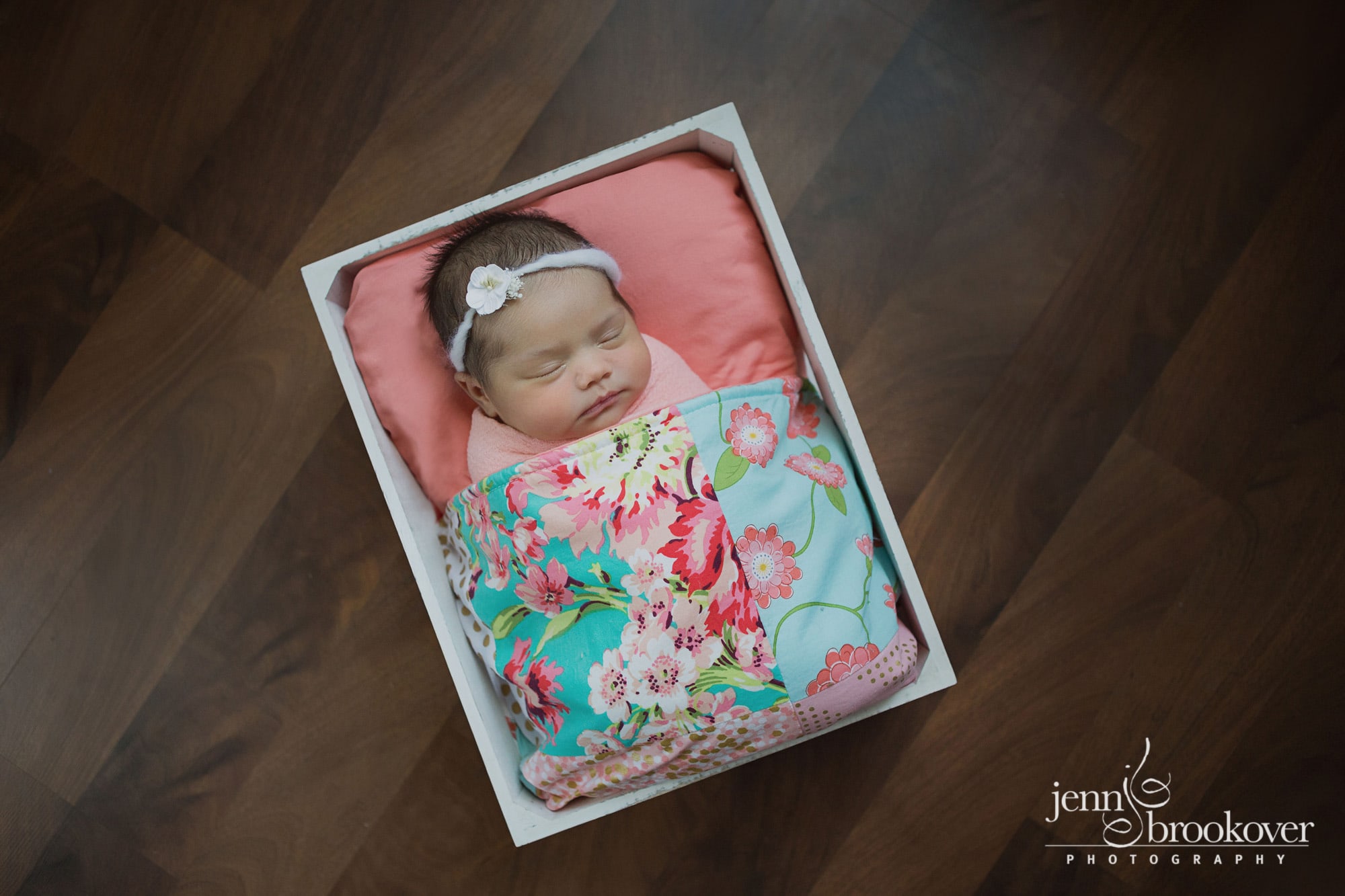 newborn in quilt, peach, coral, mint during her photo session with Jenn Brookover in Texas
