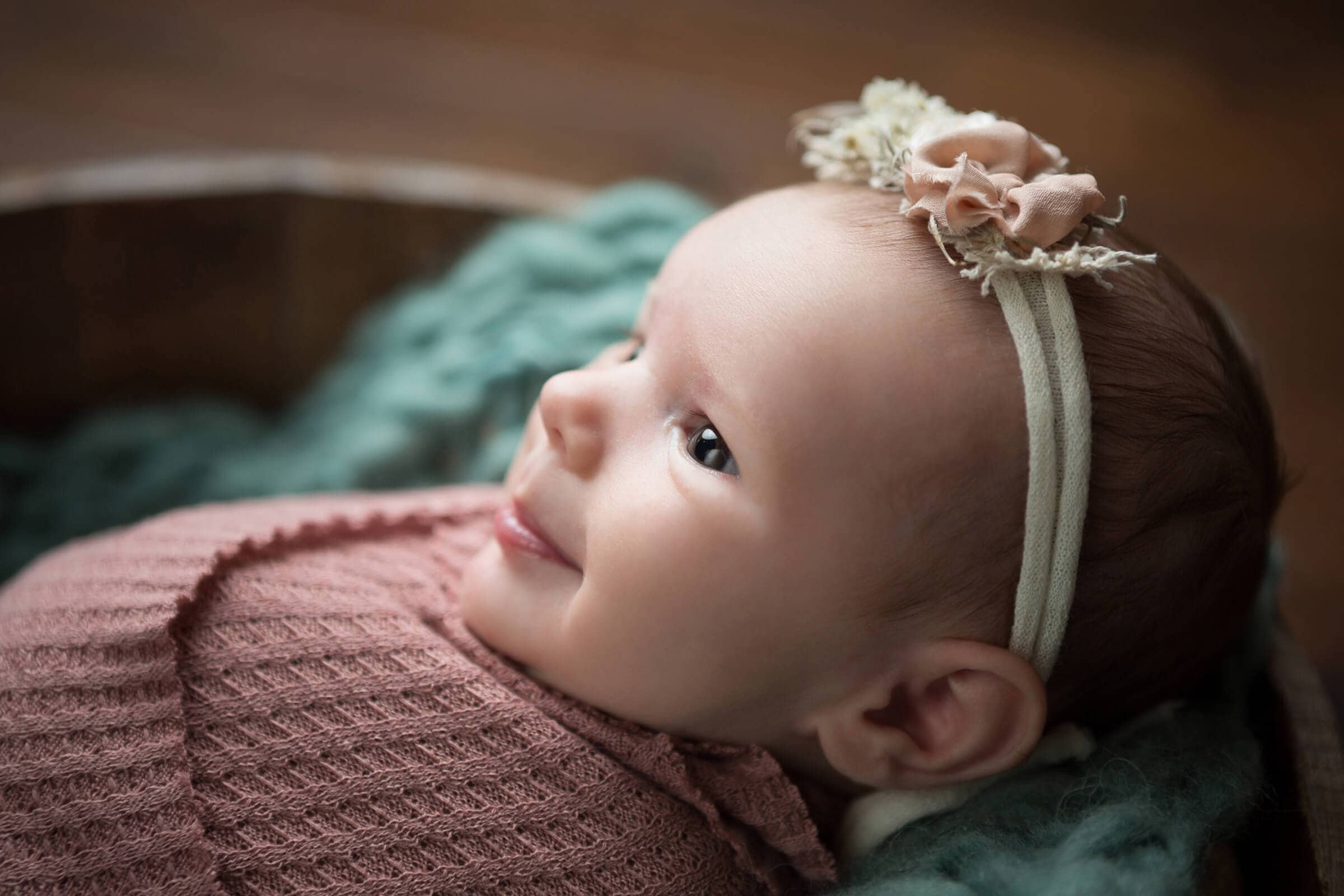 newborn smiling baby girl in pink and green