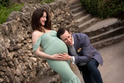 A pregnant woman is posing for a photo with a man.