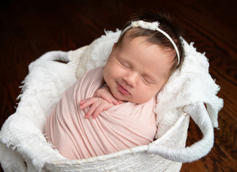 newborn baby girls smiling in pink during photo session with jenn brookover in San Antonio, Texas