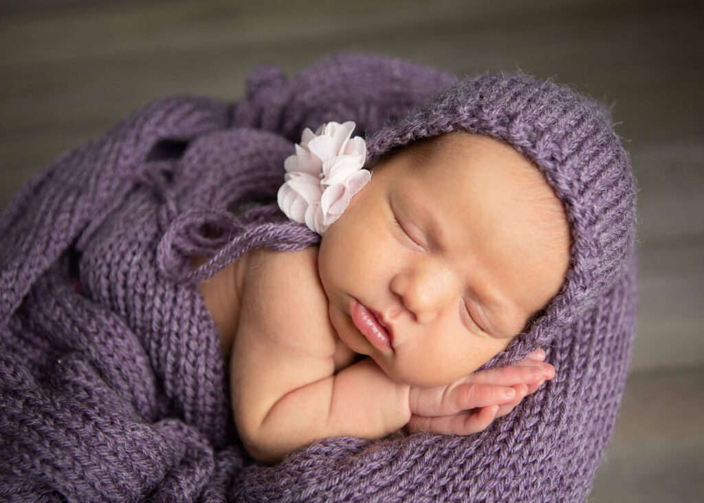 newborn baby girl in purple during photo session with jenn brookover in San Antonio, Texas