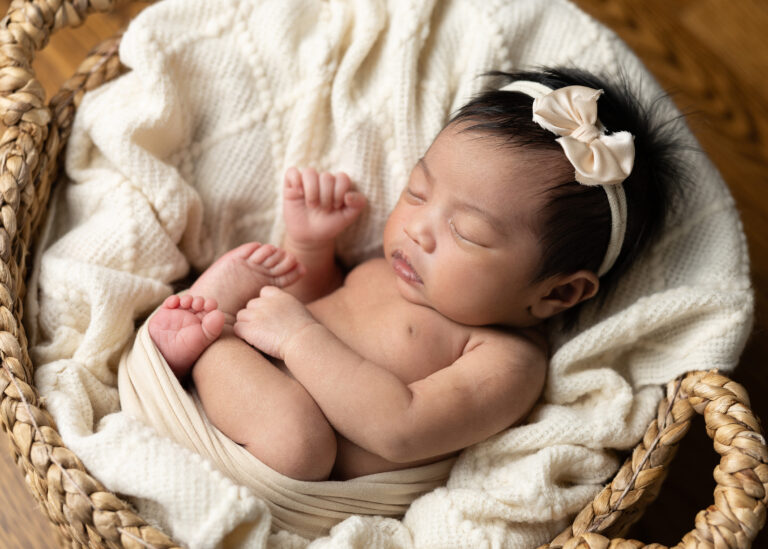 newborn girl in cream smiling and posed during photo shoot in San Antonio, Texas by Jenn Brookover