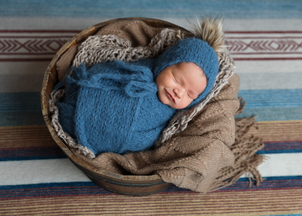 newborn boy in blue smiling and posed during photo shoot in San Antonio, Texas by Jenn Brookover