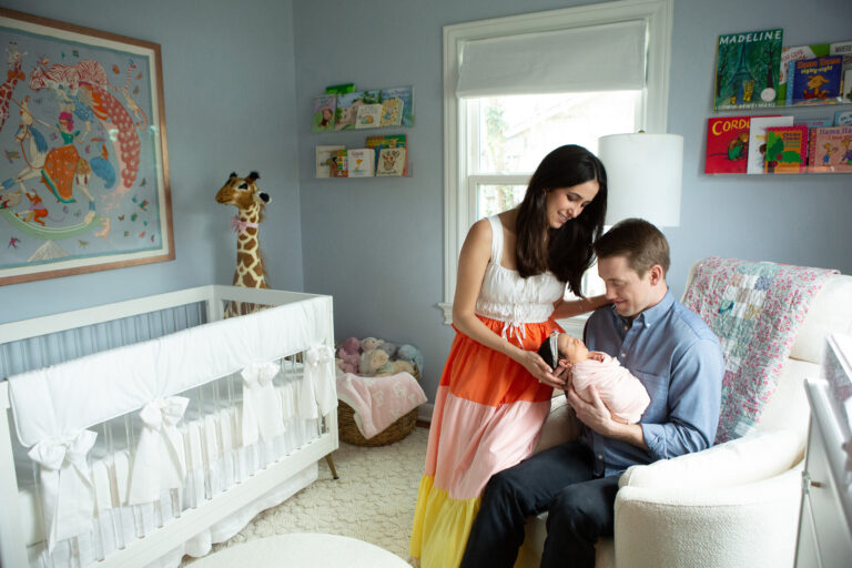 newborn baby girl wrapped in pink with parents in Alamo Height, TexAs during her photo shoot with jenn brookover photography