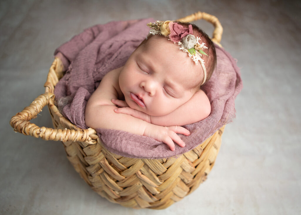 newborn baby in a basket in San Antonio, TX during her newborn photo shoot with Jenn Brookover photography