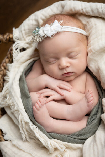 newborn baby in a basket in San Antonio, TX during her newborn photo shoot with Jenn Brookover photography